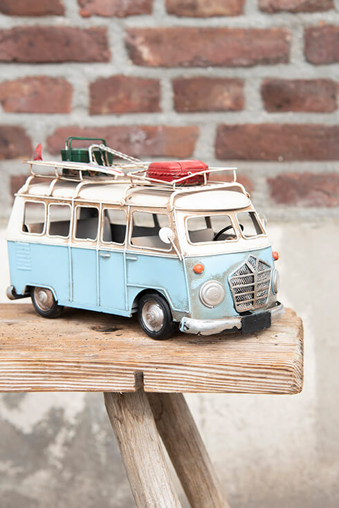 Een miniatuur voertuig van een bus op een houten bankje