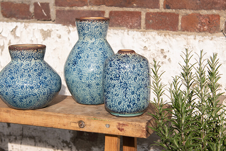 Un banc en bois avec trois vases bleus