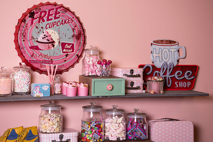 Glass jars with candy and in the background pink wall decoration