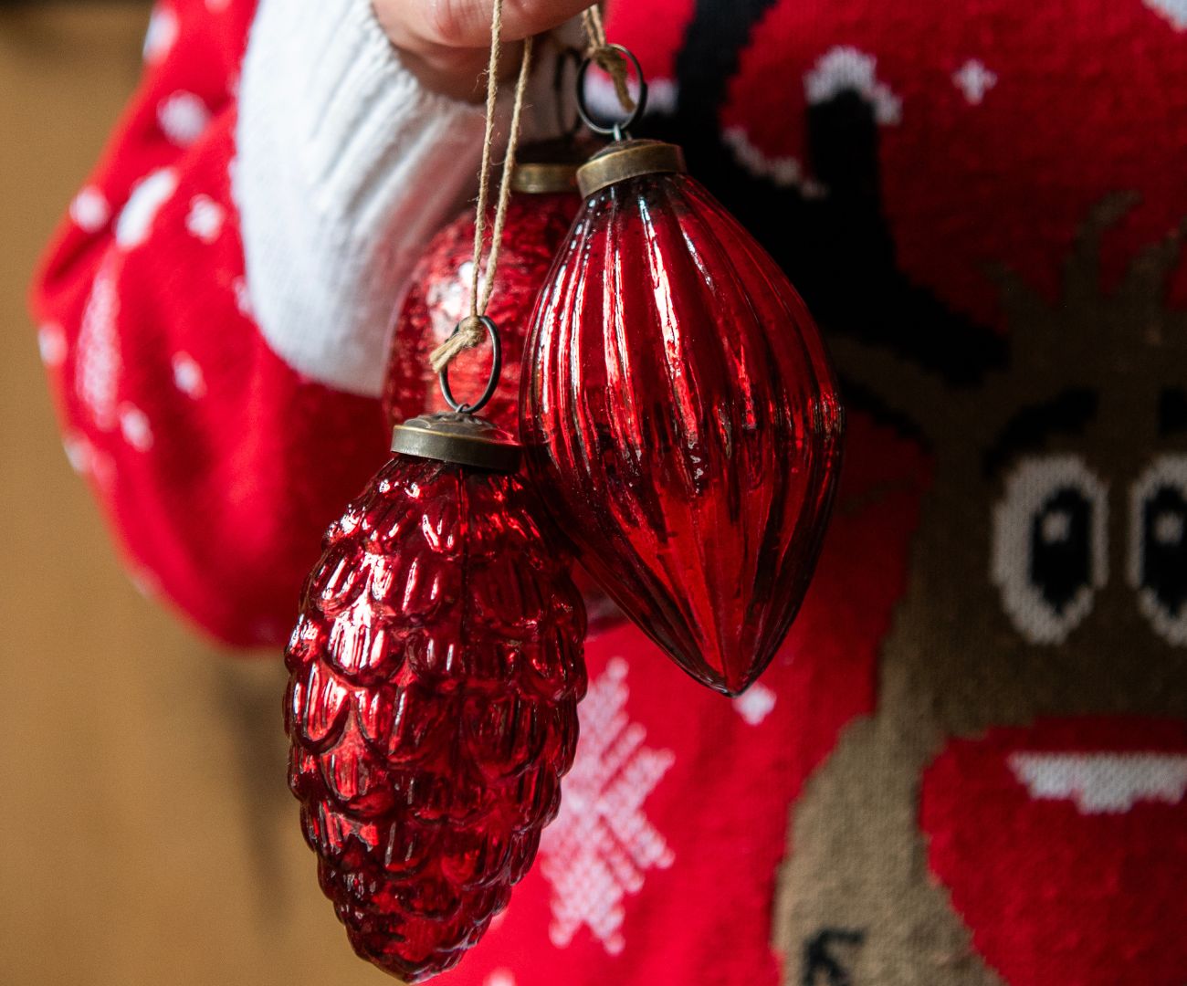 A Christmas tree ornament in the shape of a ballerina. The ballerina is dressed in a sparkling, pink tutu adorned with sequins and wears a matching tiara. Her arms are gracefully raised, and she has a delicate, joyful expression. In the background, you can see more glittering decorations and a second ballerina ornament. The Christmas tree itself is richly adorned with white and light pink tones, creating a soft and enchanting atmosphere. The focus is on the ballerina in the foreground, with a gentle blur in the background, giving a dreamy effect.